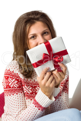 Festive brunette holding a gift with red ribbon