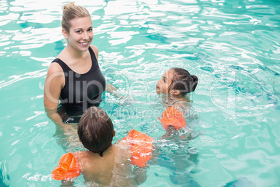 Cute swimming class in pool with coach