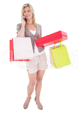 Happy blonde with shopping bags on the phone