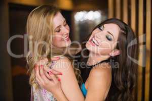 Attractive friends hugging and smiling