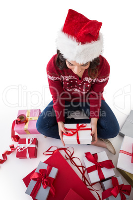 Festive brunette sitting and wrapping christmas presents