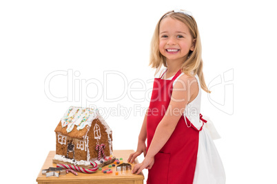 Festive little girl making gingerbread house