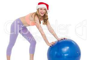 Festive blonde woman using exercise ball