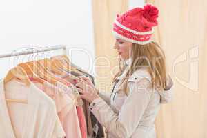 Pretty blonde looking at clothes on rail