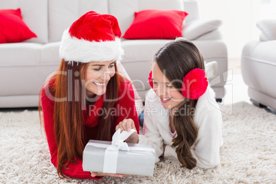 Festive mother and daughter opening a christmas gift