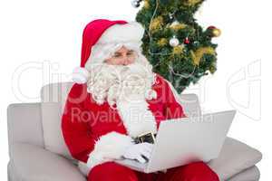 Santa using his laptop on the couch