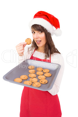 Brunette in santa hat showing hot cookies
