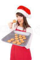 Brunette in santa hat showing hot cookies