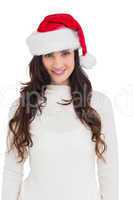 Beautiful brunette in santa hat smiling at camera