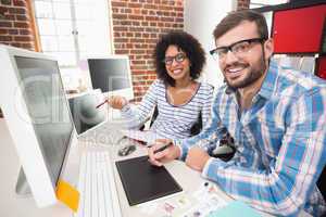 Smiling photo editors using digitizer in office