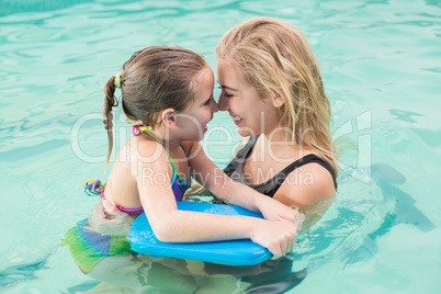 Happy mother and daughter in the swimming pool