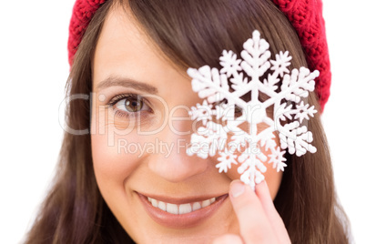 Festive brunette holding snowflake decoration