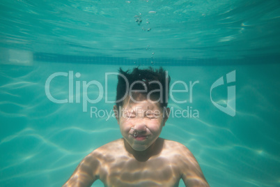 Cute kid posing underwater in pool