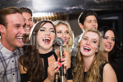 Happy friends singing karaoke together