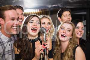 Happy friends singing karaoke together