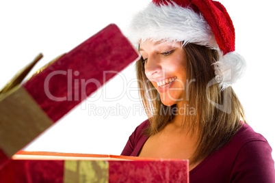 Pretty brunette in santa hat opening a gift