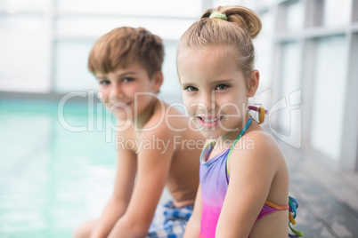 Cute little siblings sitting poolside