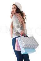 Brunette keeping a secret and holding shopping bags