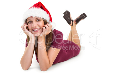 Festive brunette lying on the floor smiling at camera