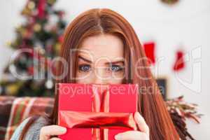 Festive redhead with gift on the couch