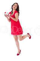 Stylish brunette in red dress holding gift