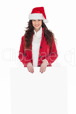 Cheerful brunette showing white poster