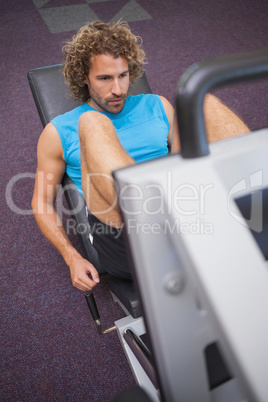 Handsome man doing leg presses in gym