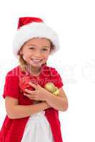 Cute little girl wearing santa hat holding baubles