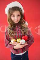 Festive little girl smiling at camera holding baubles