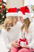 Festive mother and daughter smiling at each other