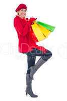 Happy blonde in winter clothes holding shopping bags
