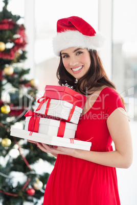 Brunette in red dress holding pile of gift