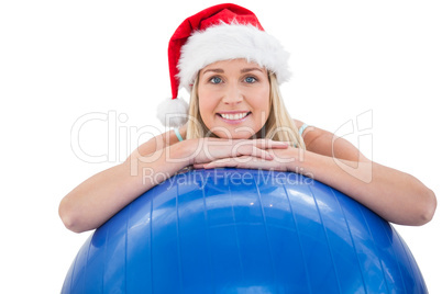 Festive fit blonde leaning on exercise ball