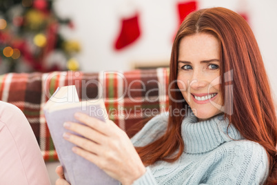 Festive redhead reading on the couch