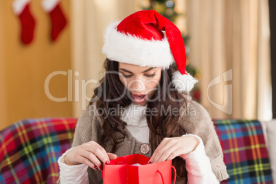 Brunette looking in gift bag at christmas