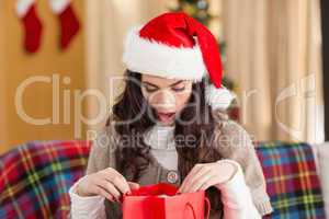 Brunette looking in gift bag at christmas