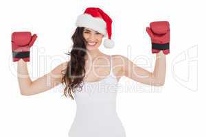 Festive brunette in boxing gloves with arms raised
