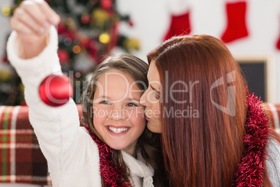 Festive mother and daughter holding baubles