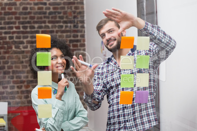 Business team looking at sticky notes on window