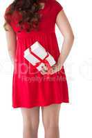 Brunette in red dress hiding gift