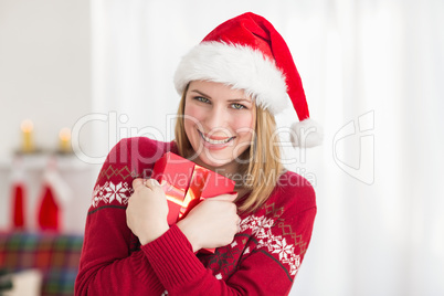 Festive pretty woman hugging her gift