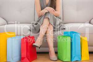 Elegant woman sitting on the couch with shopping bags