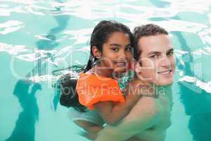 Cute little girl learning to swim with coach