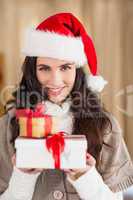 Festive brunette in santa hat holding gifts