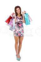 Smiling brunette in floral dress holding shopping bags
