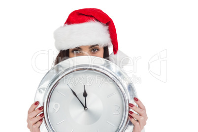 Festive brunette holding a clock