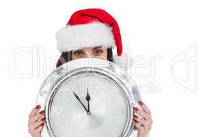 Festive brunette holding a clock