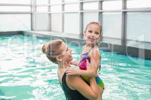 Cute little girl learning to swim with mum