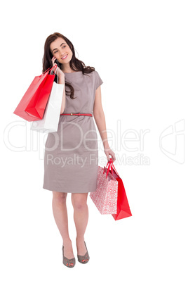 Happy brunette with shopping bags on the phone