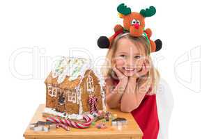 Festive little girl making gingerbread house